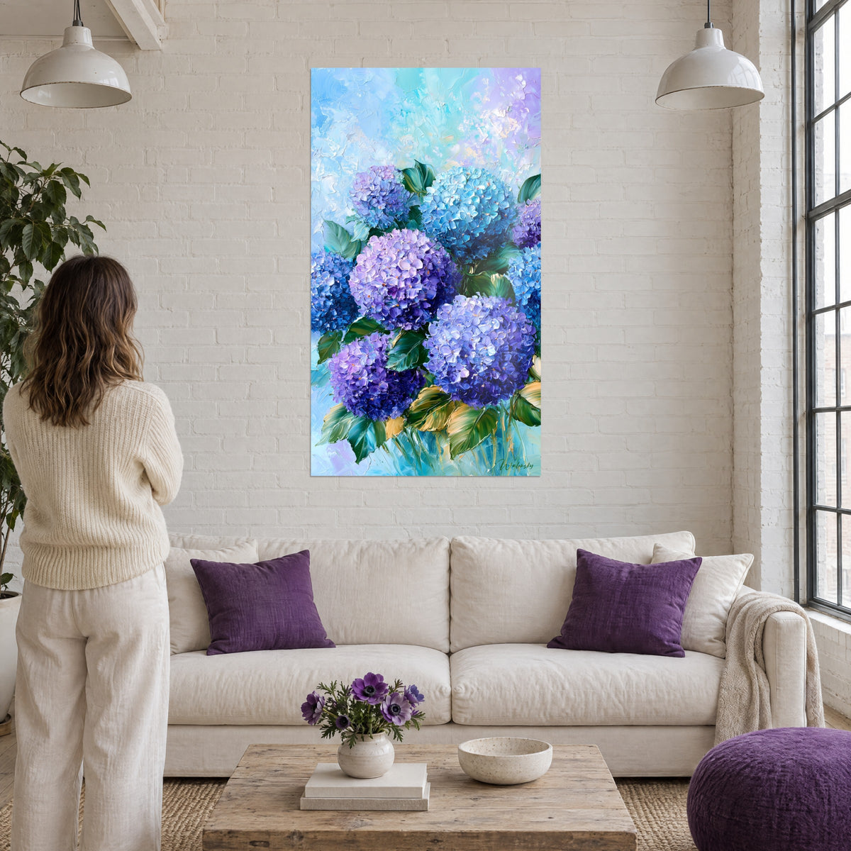Gemälde Blaue und violette Hortensien mit grünen Blättern, pastoser Farbauftrag mit dem Spachtel, über einem Sofa in einem hellen Wohnzimmer