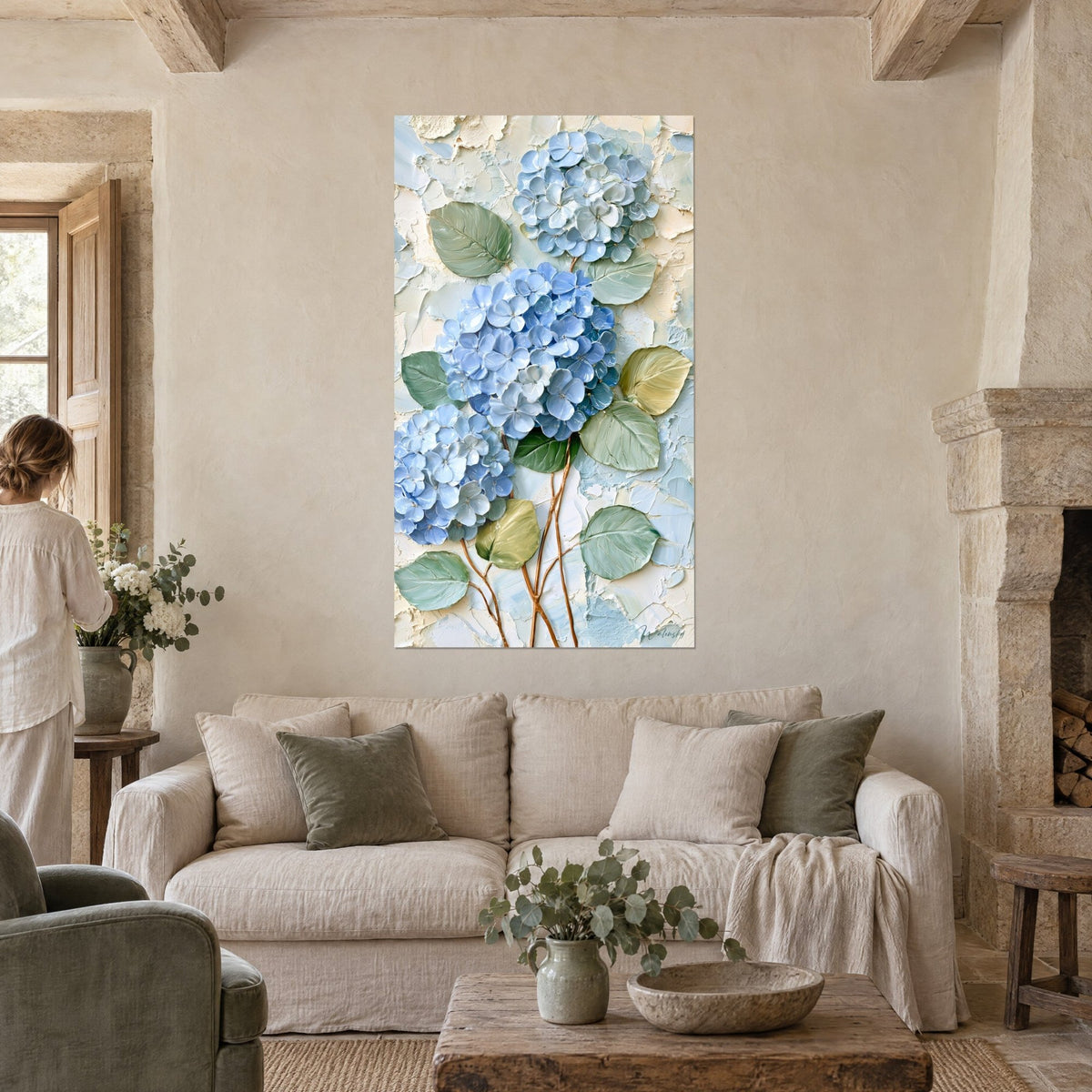 Cuadro hortensias azul cielo en pasta gruesa, hojas verde salvia, tallos cobrizos, encima de un sofá en un salón luminoso