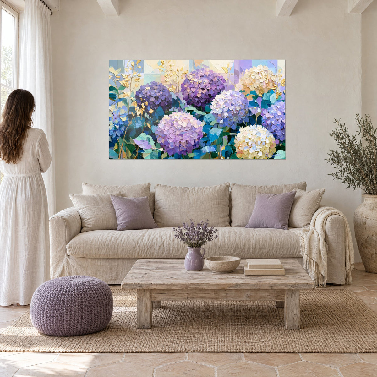 Cuadro de hortensias enormes en violeta y crema con empastes gruesos, hojas doradas, sobre un sofá en un salón luminoso