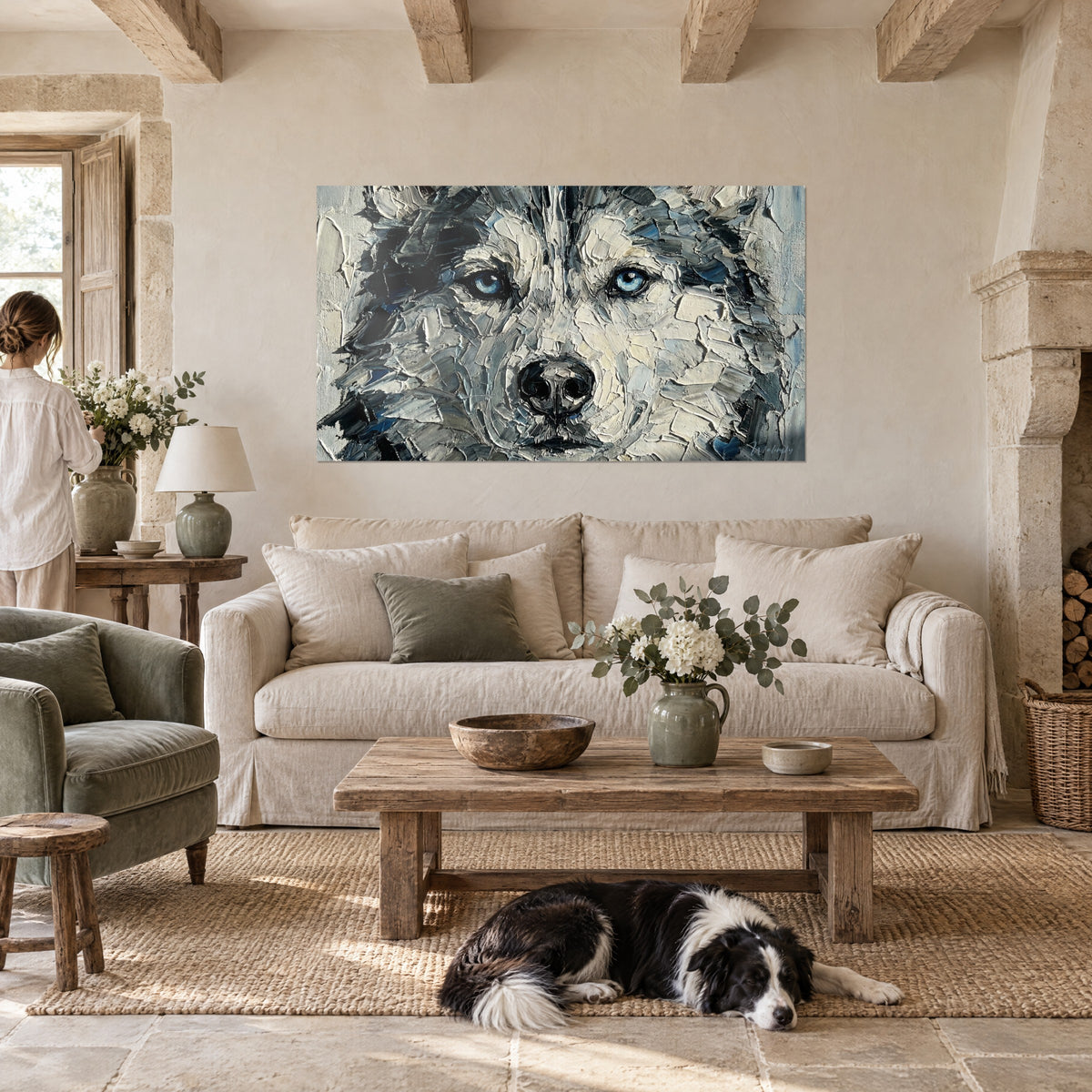 Gemälde eines sibirischen Huskys mit gletscherblauen Augen, Farbauftrag in Perlgrau und Schwarz, zwei Personen von hinten, über einem Sofa in einem hellen Wohnzimmer