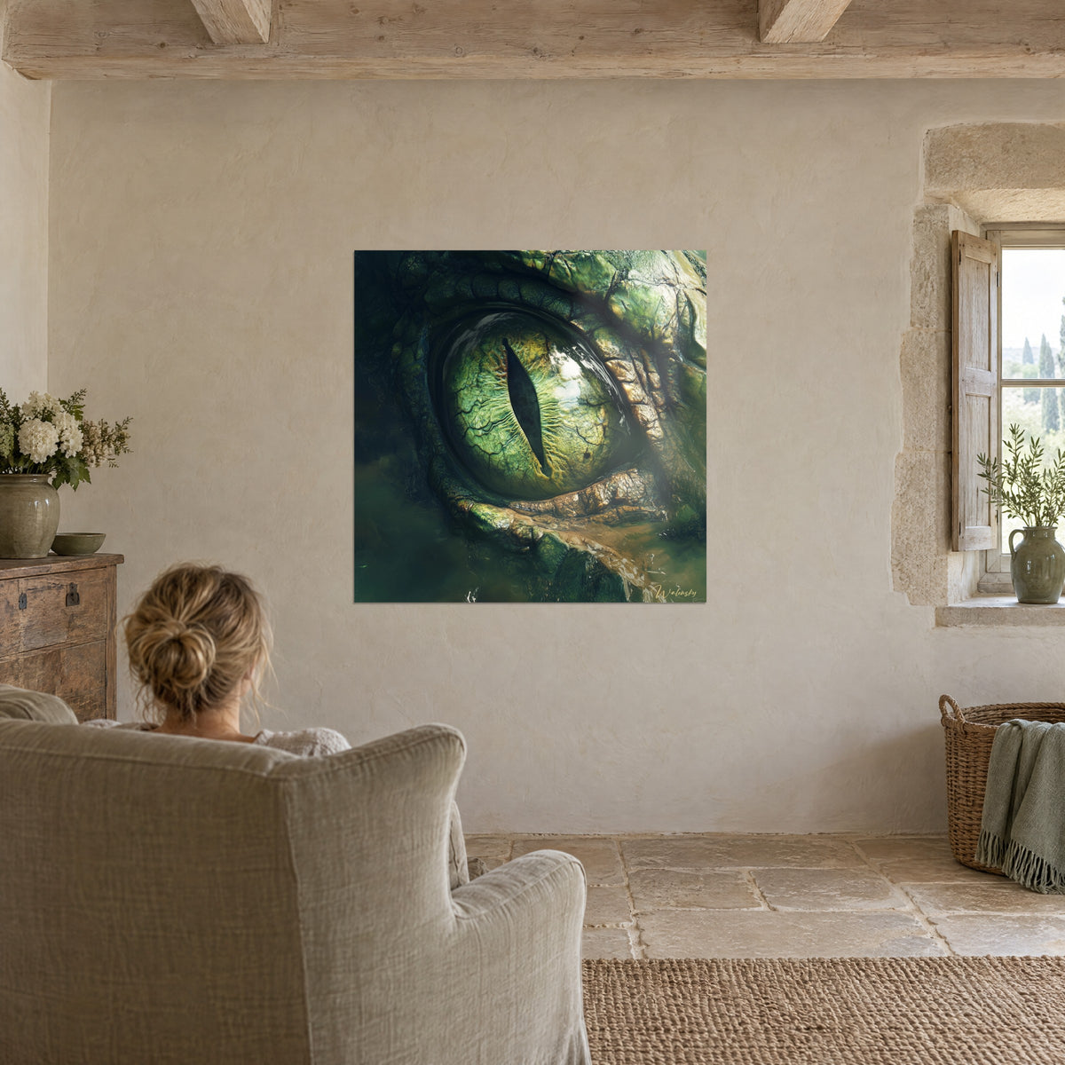 Wall art pale green snake eyeball streaked with gold, black slit pupil, woman seen from behind in a grey armchair, stone wall