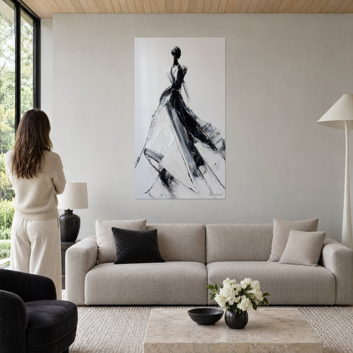 Tableau silhouette féminine en robe de bal noire et ivoire, coups de spatule épais, femme de dos, au-dessus d'un canapé dans un salon lumineux