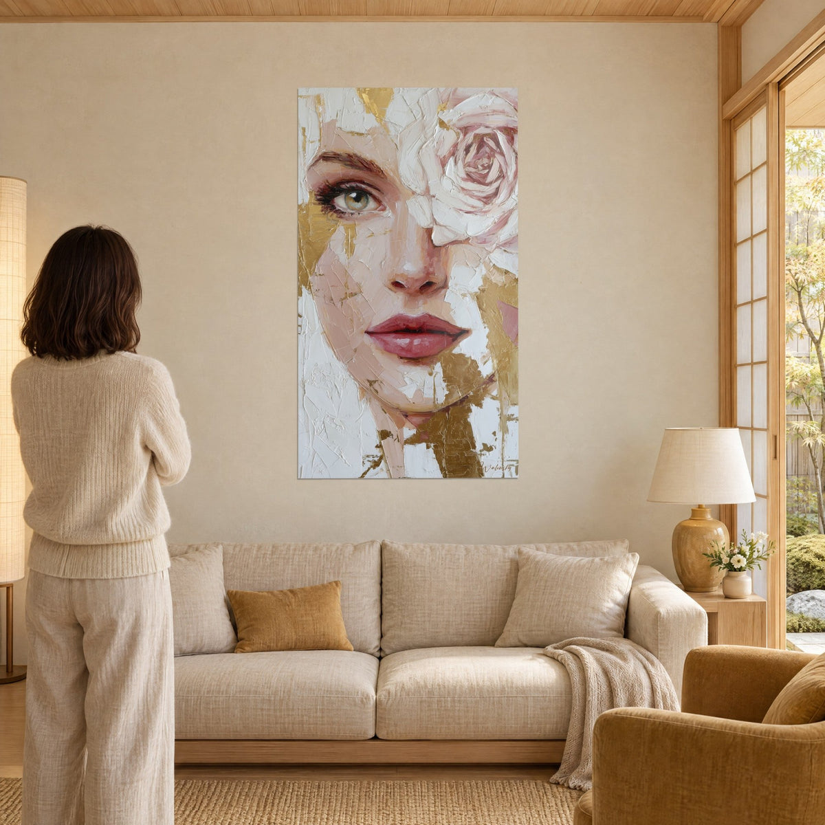 Tableau visage de femme aux lèvres rose framboise, rose blanche sur l'œil, feuille d'or en éclats, au-dessus d'un canapé dans un salon lumineux