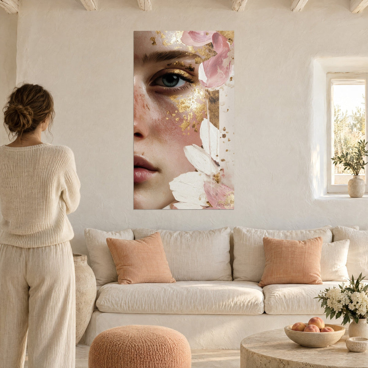 Tableau visage de femme aux paillettes d'or et pétales rose poudré, œil gris-vert, femme de dos au-dessus d'un canapé dans un salon lumineux
