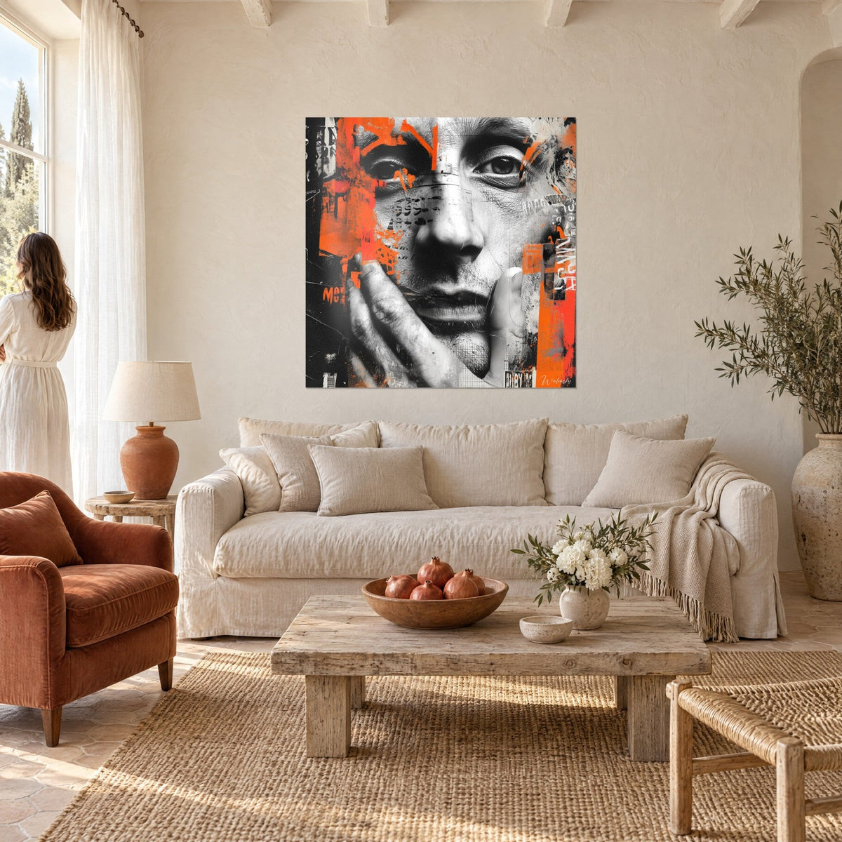 Tableau portrait en noir et blanc, main sur la joue, taches orange vif, femme de dos, au-dessus d'un canapé dans un salon lumineux