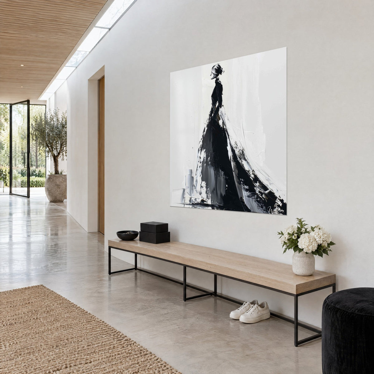Tableau femme élancée à chignon, robe ample d'encre noire et d'écume blanche, accroché de trois quarts dans un couloir clair
