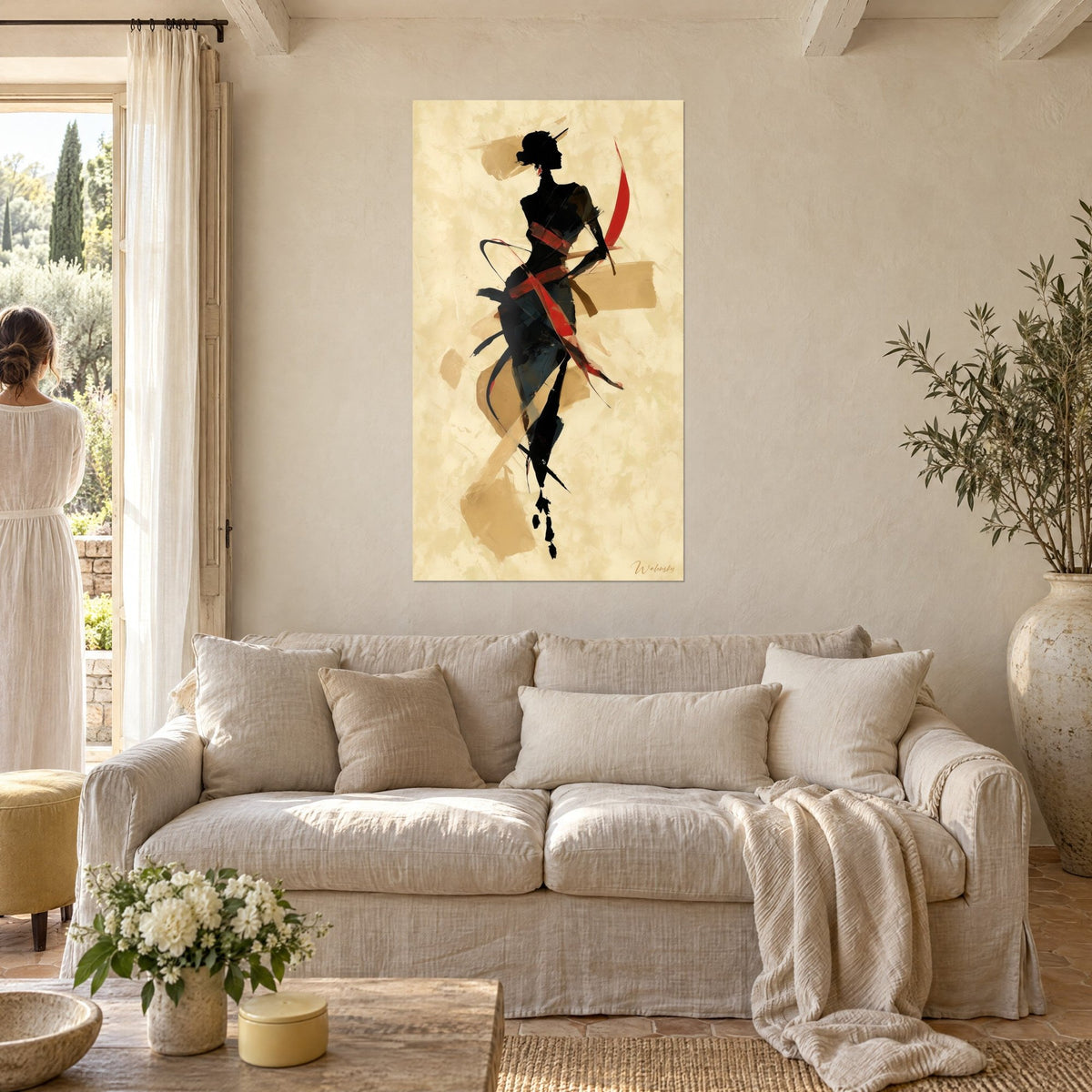 Tableau élégante silhouette noire aux rubans rouges croisés sur fond beige texturé, au-dessus d'un canapé dans un salon lumineux