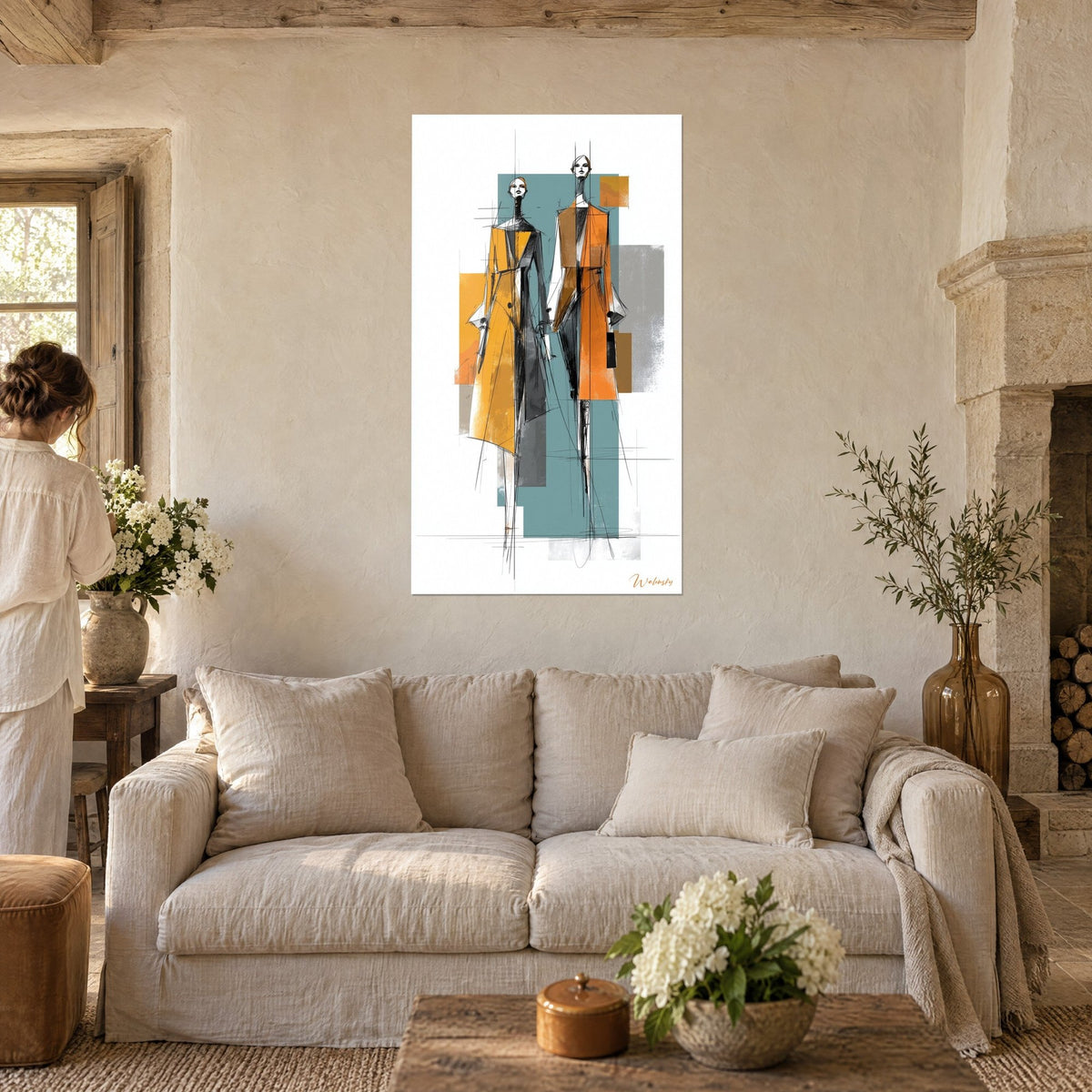 Tableau mannequins croqués en manteaux ocre et orange sur aplat bleu canard, femme de dos, au-dessus d'un canapé dans un salon lumineux