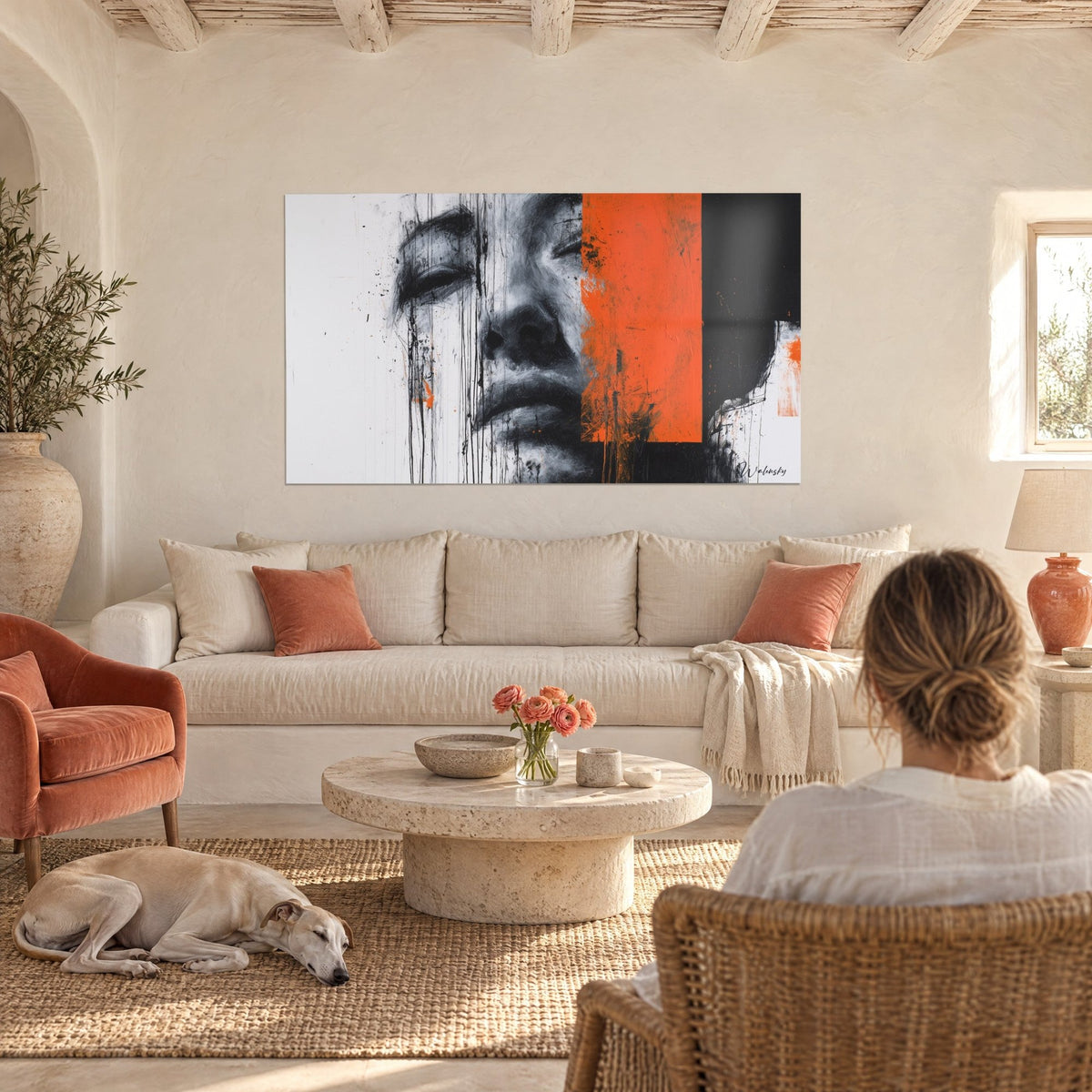 Tableau visage de femme en fusain gris, bloc orange vif et coulures noires, au-dessus d'un canapé dans un salon lumineux
