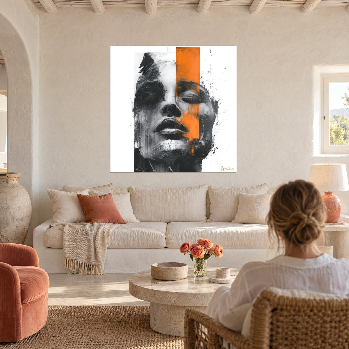 Tableau visage de femme en noir et blanc, bande orange vif sur l'œil, au-dessus d'un canapé dans un salon lumineux