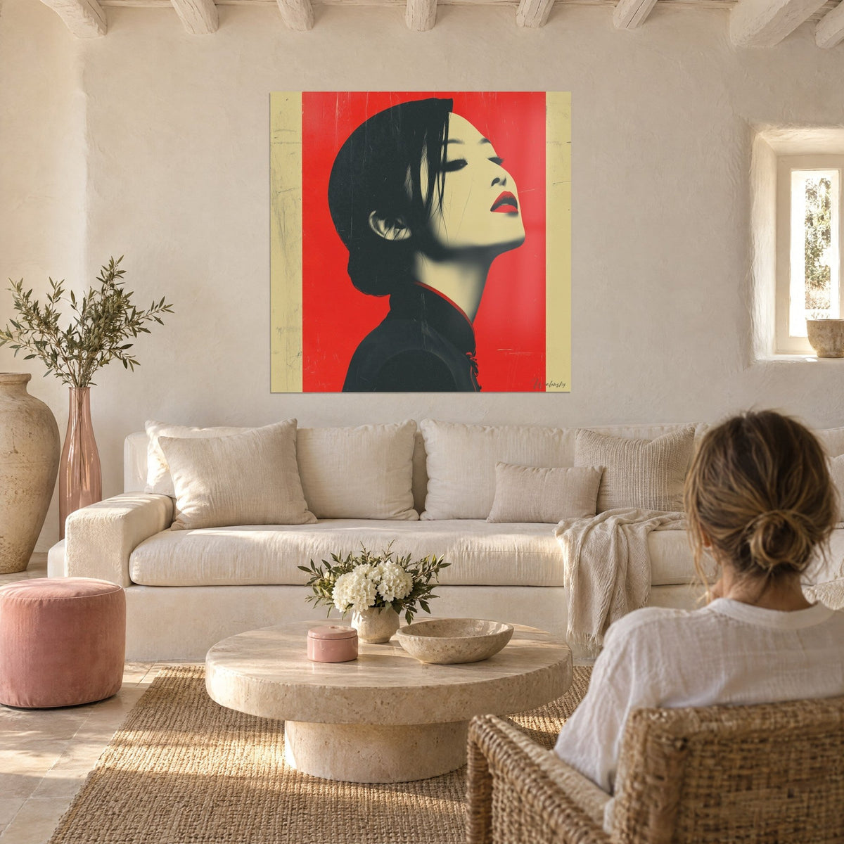 Tableau profil de femme au menton relevé, aplat rouge vif et cheveux noirs, lèvres écarlates, au-dessus d'un canapé dans un salon lumineux