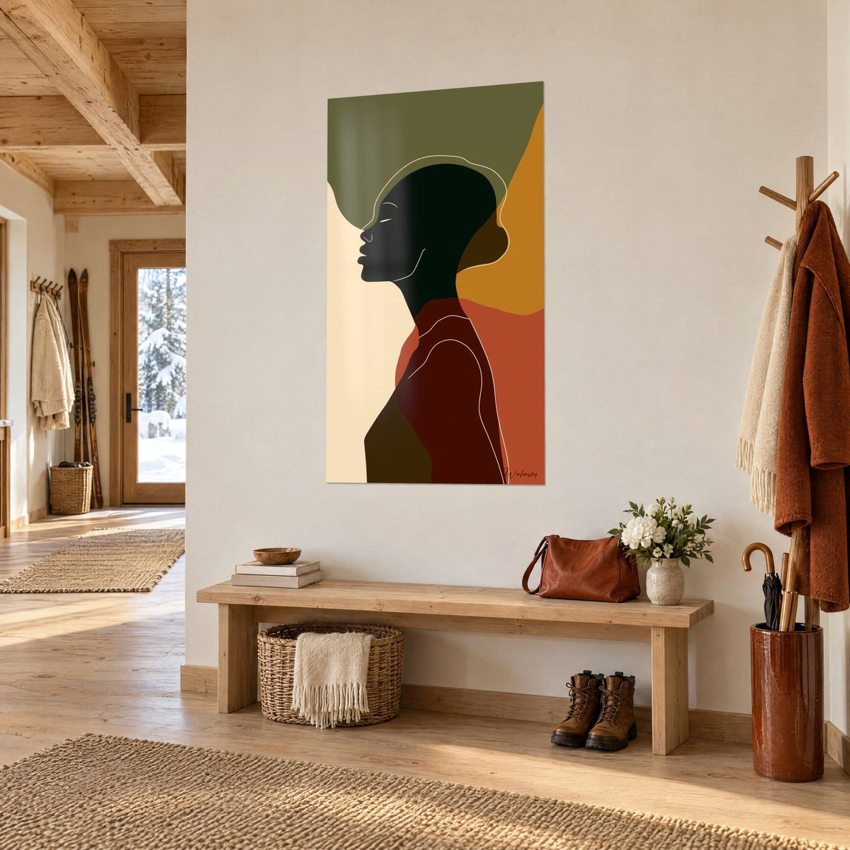Tableau silhouette crâne rasé de profil, aplats olive, moutarde et terracotta, en vue de trois-quarts dans l'entrée d'un chalet