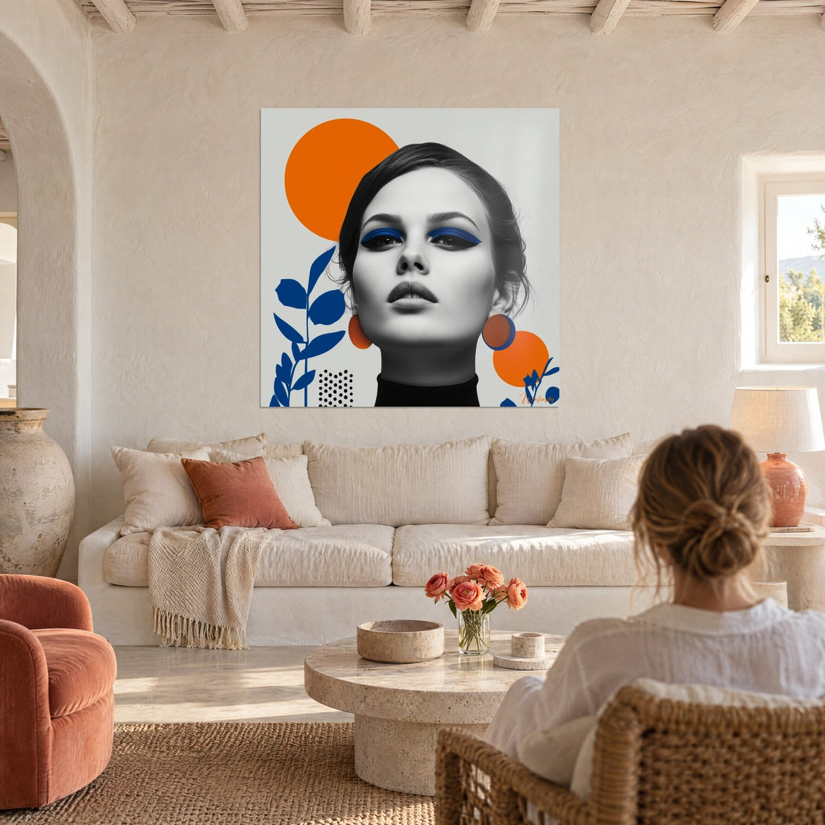 Tableau visage de femme maquillage bleu électrique, disques orange et feuillages indigo, au-dessus d'un canapé dans un salon lumineux