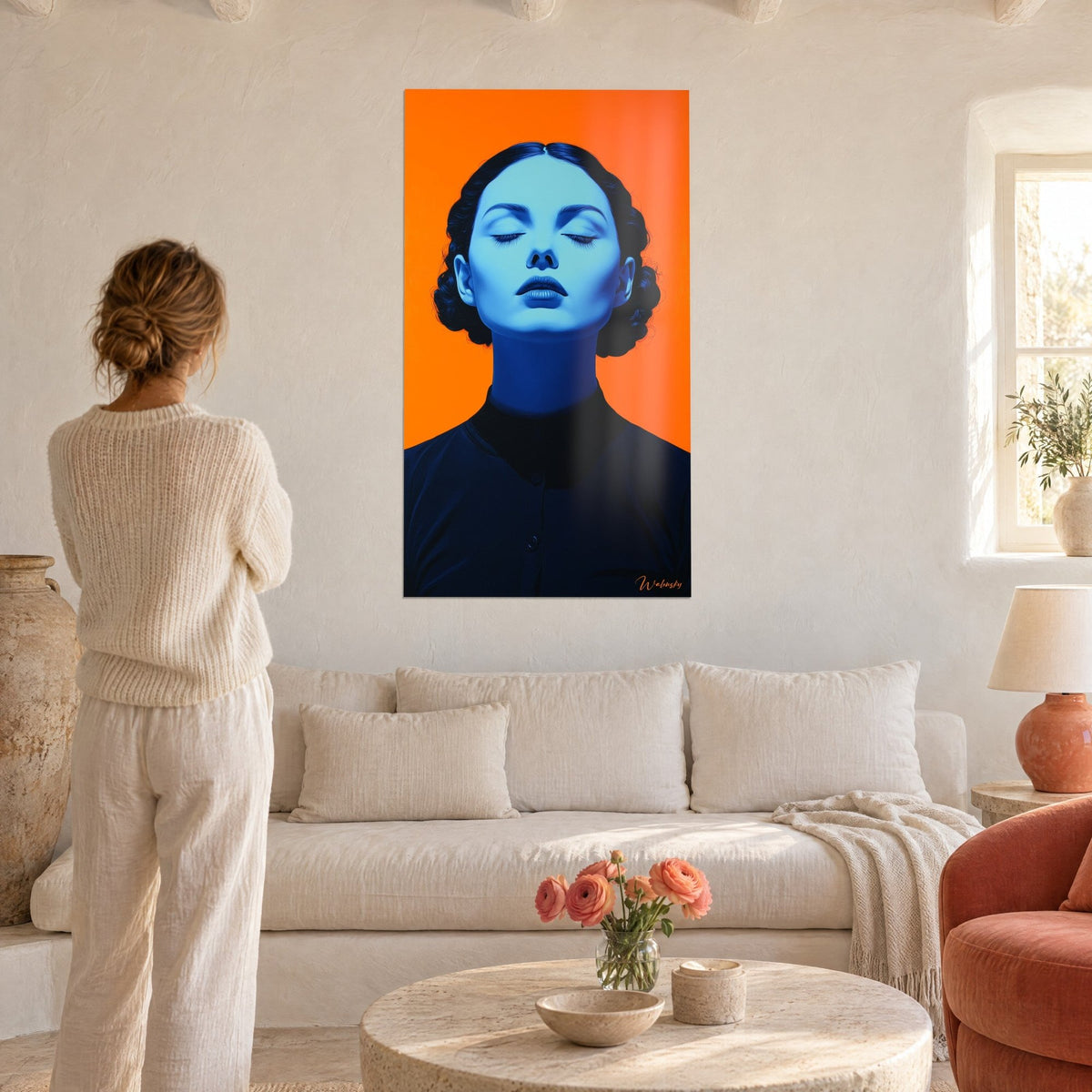 Quadro ritratto femminile con palpebre chiuse, pelle blu ghiacciaio su sfondo arancione vivo, sopra un divano in un soggiorno luminoso