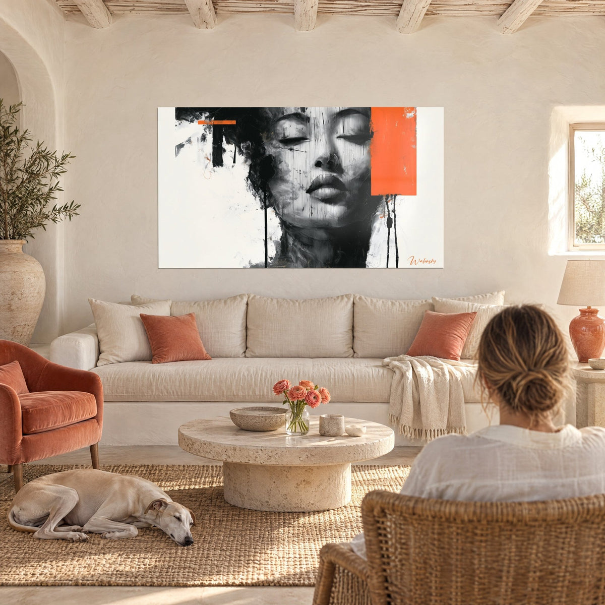 Tableau visage de femme aux paupières closes, noir et blanc rayé, aplat orange vif, au-dessus d'un canapé dans un salon lumineux