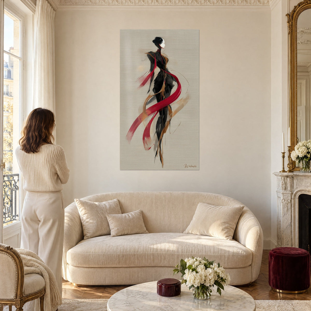 Tableau silhouette élancée en robe noire drapée d'un ruban rouge carmin, fond lin grège, au-dessus d'un canapé dans un salon lumineux