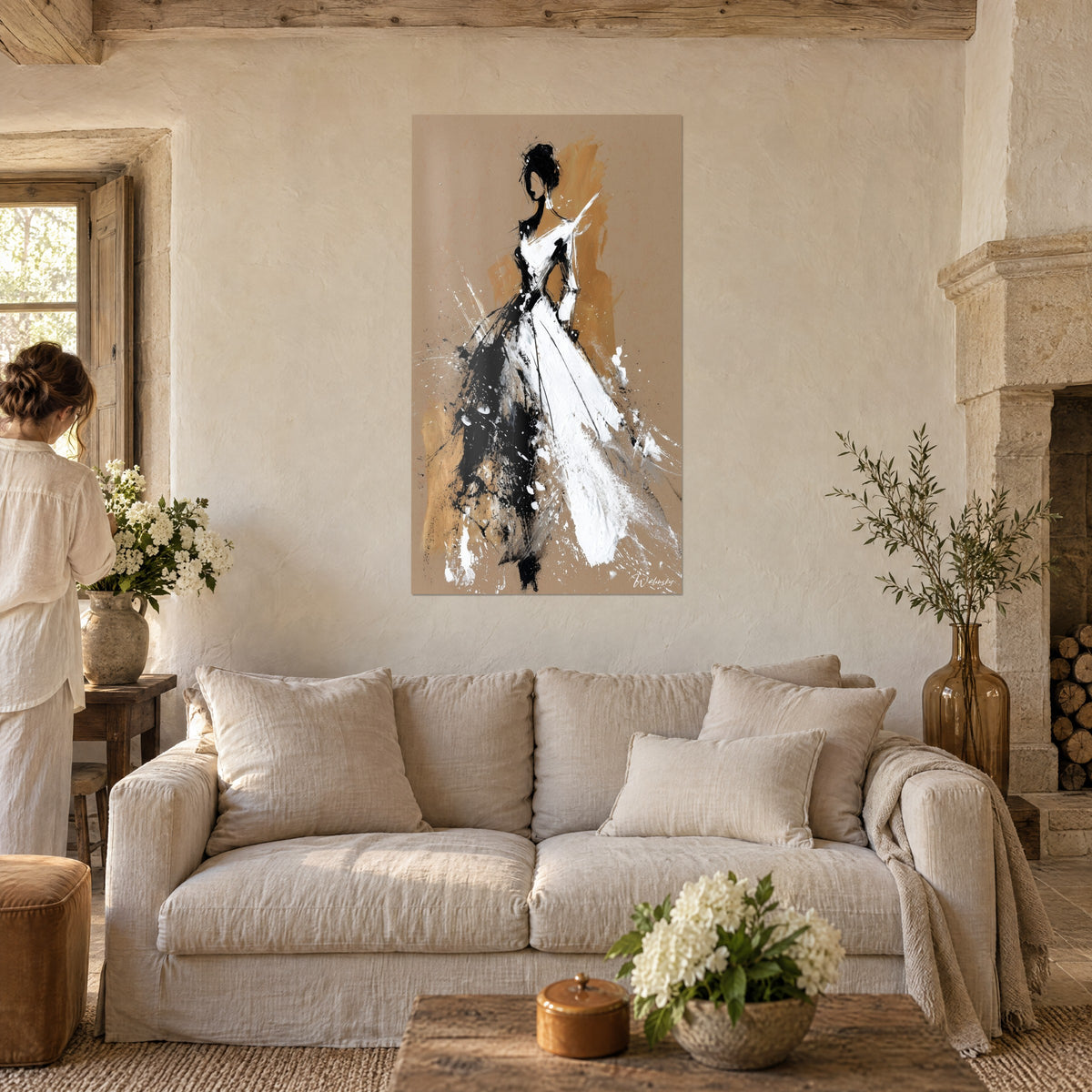 Tableau silhouette féminine en robe blanche éclaboussée, fond kraft et ocre, noir vif, au-dessus d'un canapé dans un salon lumineux