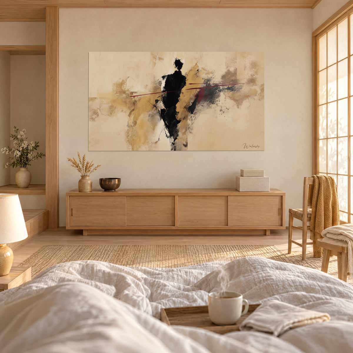 Wall art slender black figure with scarlet threads on ochre and sand veil, facing the bedspread, above a bed in a bright bedroom
