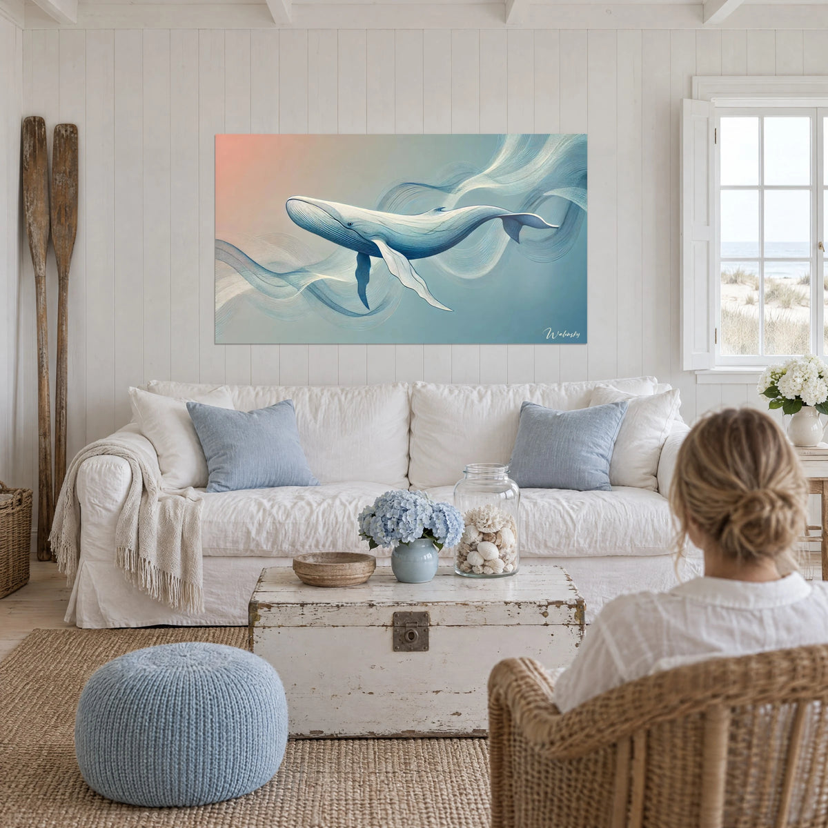 Gemälde Pottwal in Weiß mit feinen blauen Linien, Verlauf in Korallrot und Blau, über einem Sofa in einem hellen Wohnzimmer