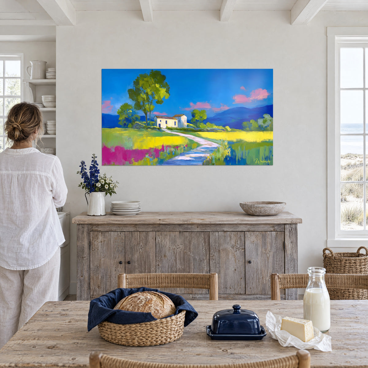 Schilderij witte boerderij tussen koolzaadvelden en magentakleurige bloemen, azuurblauwe lucht, opgehangen in een eetkamer aan zee