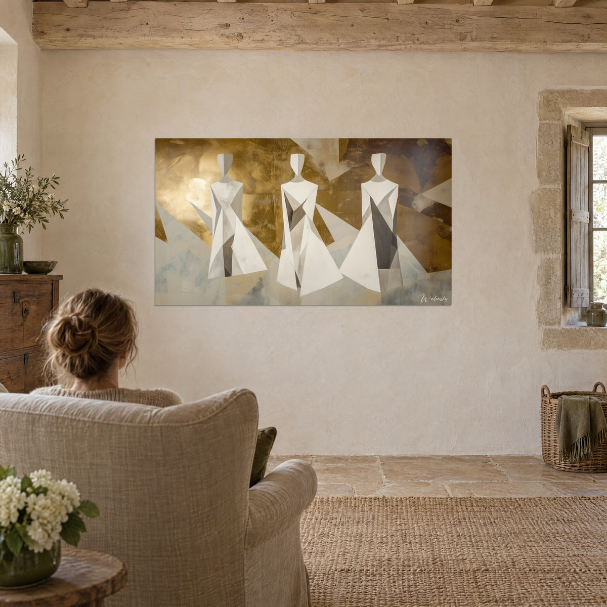 Schilderij trio van geometrische effigies met gefacetteerde witte gewaden, geoxideerde gouden en okerachtergrond, tegenover een beige linnen fauteuil