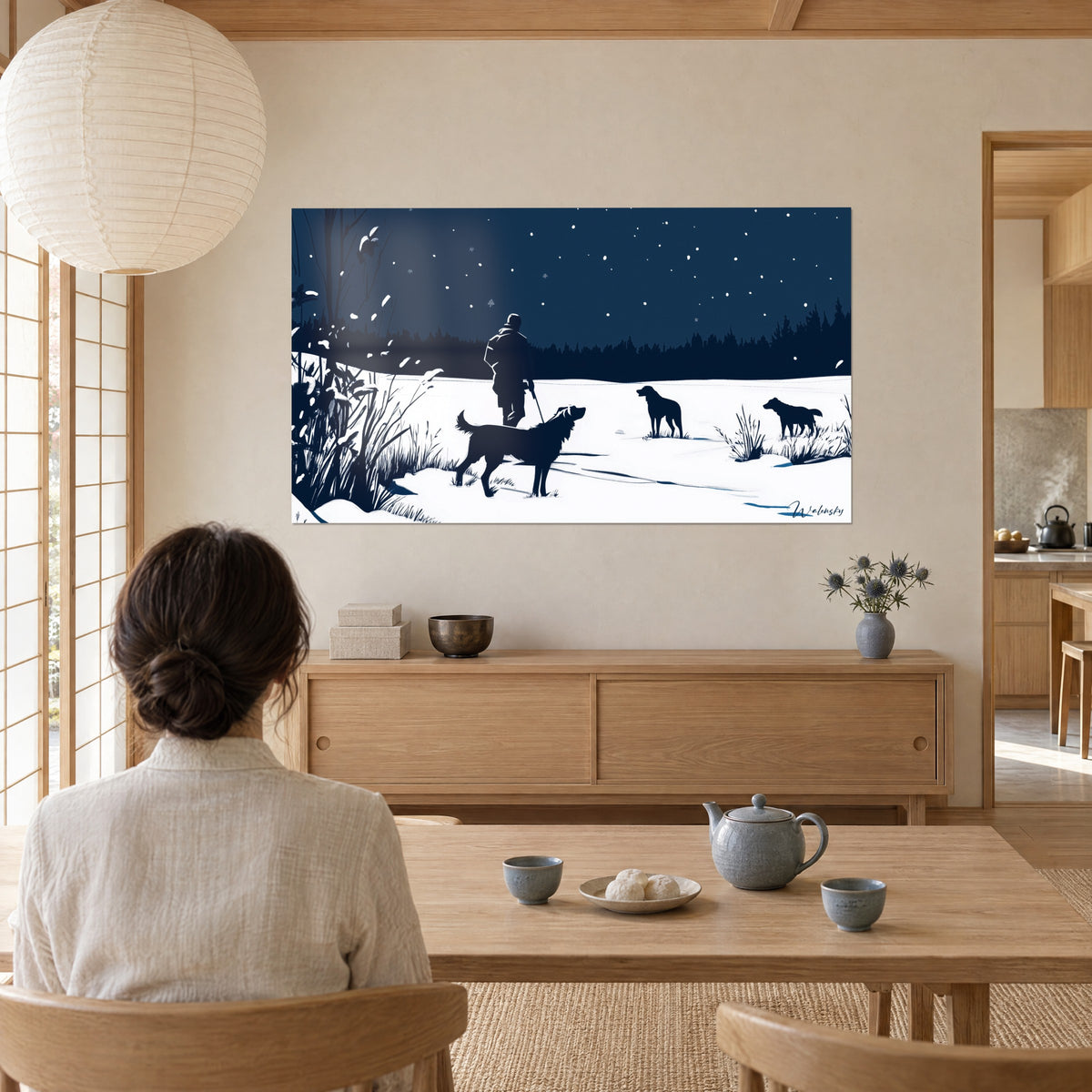 Wall art nocturnal winter scene, man seen from behind and labrador in midnight blue on white snow, watched by a woman seated at a table in a japandi room