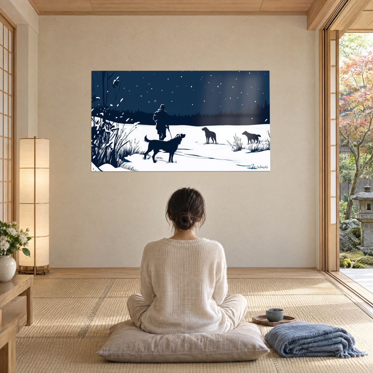 Wall art winter hunt in midnight blue and white, conifer forest and snowflakes, contemplated by a woman sitting cross-legged on a grey cushion