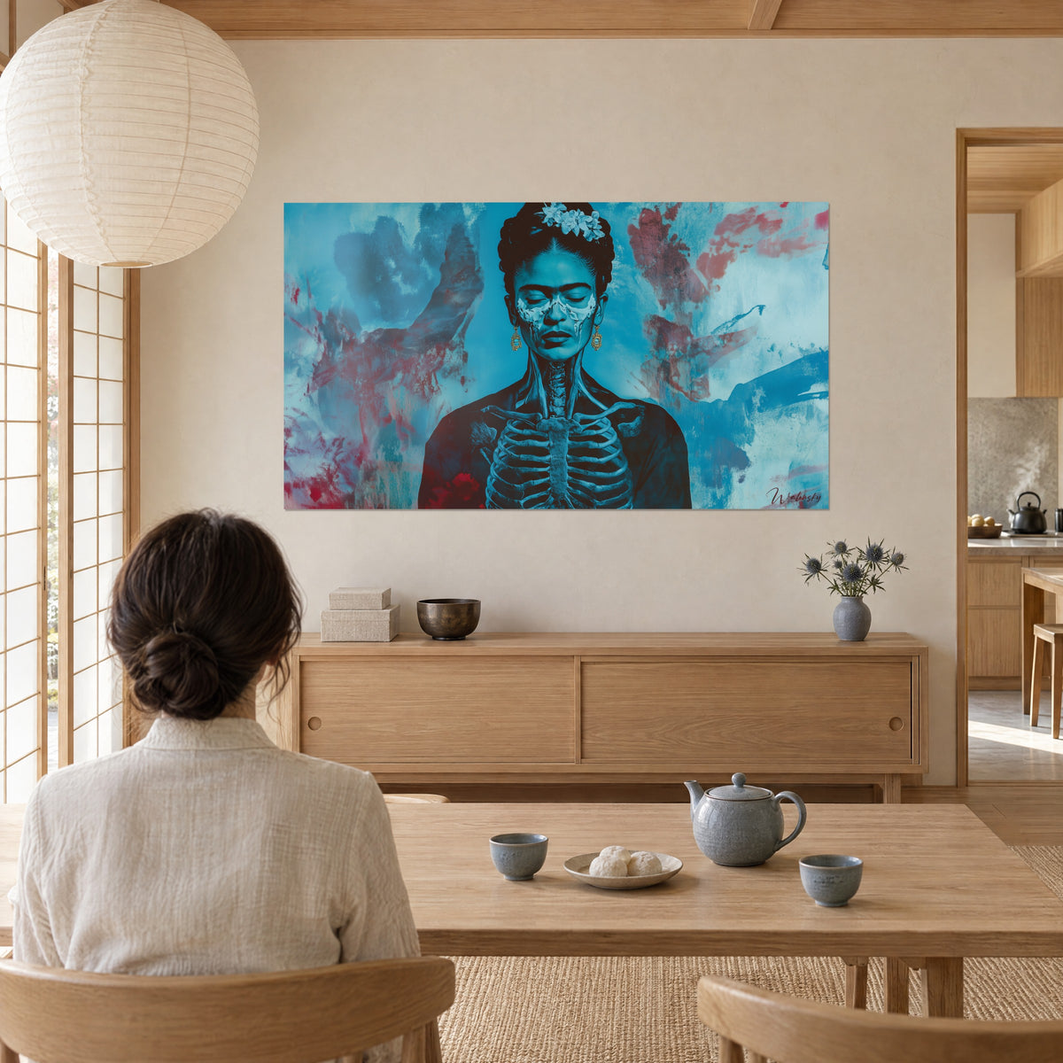 Schilderij vrouwelijke figuur met zichtbare ribben, turkoois en bloedrood kleurenspel, bekeken door een vrouw van achteren, thee geserveerd op een houten salontafel