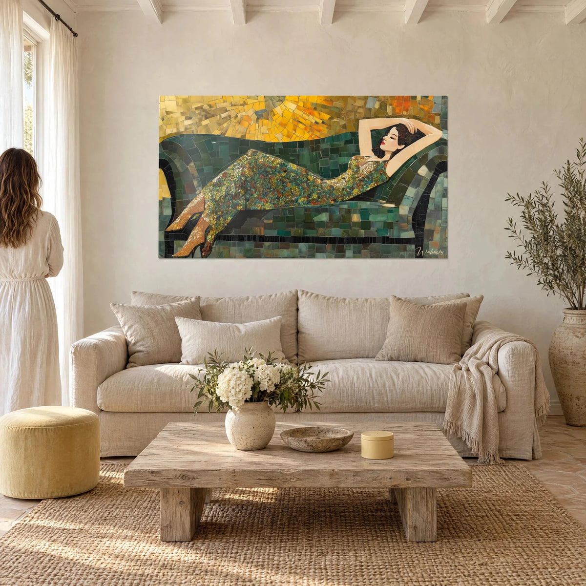Wall art of a reclining woman in a green and gold mosaic dress, yellow sun, two people seen from behind, above a sofa in a bright living room
