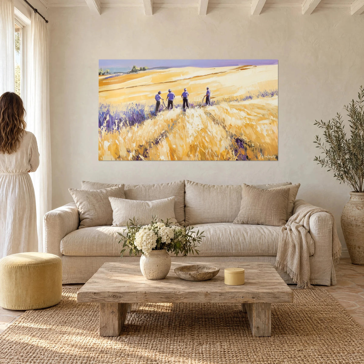 Quadro mietitori in camicie lilla in un campo di grano dorato, lavanda viola in primo piano, sopra un divano in un soggiorno luminoso