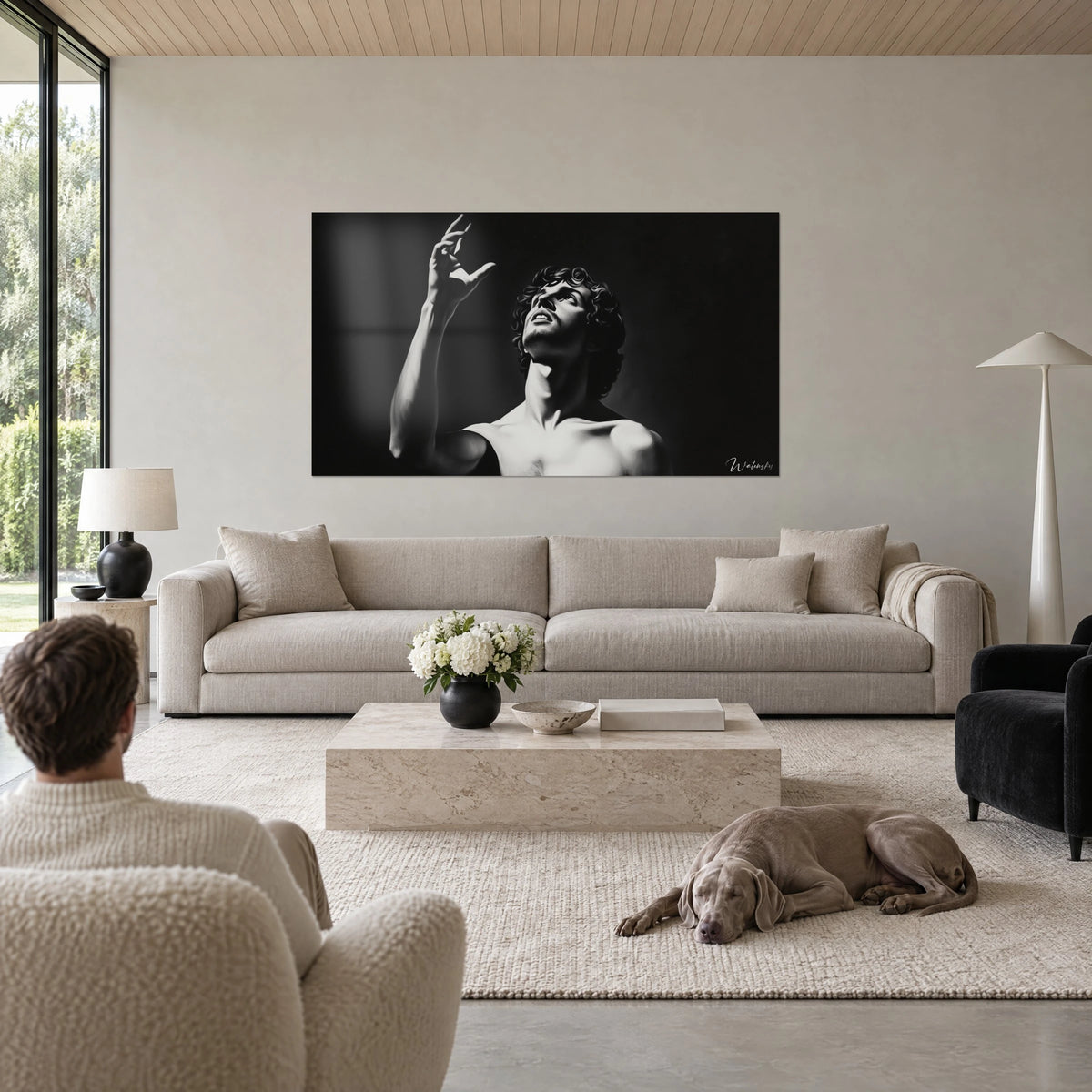 Gemälde eines lockigen jungen Mannes, Arm erhoben und Blick zum Himmel gerichtet, Schwarzweiß auf dunklem Hintergrund, über einem Sofa in einem hellen Wohnzimmer
