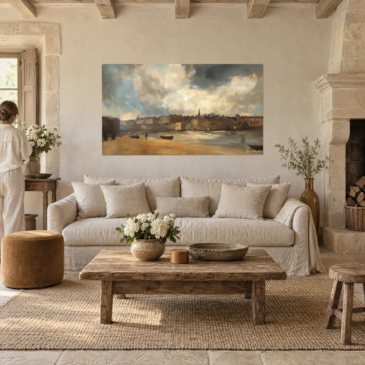 Quadro panorama di una città olandese sotto nuvole color crema e grigio-azzurro, riva ocra, chiatte scure, sopra un divano in un soggiorno luminoso