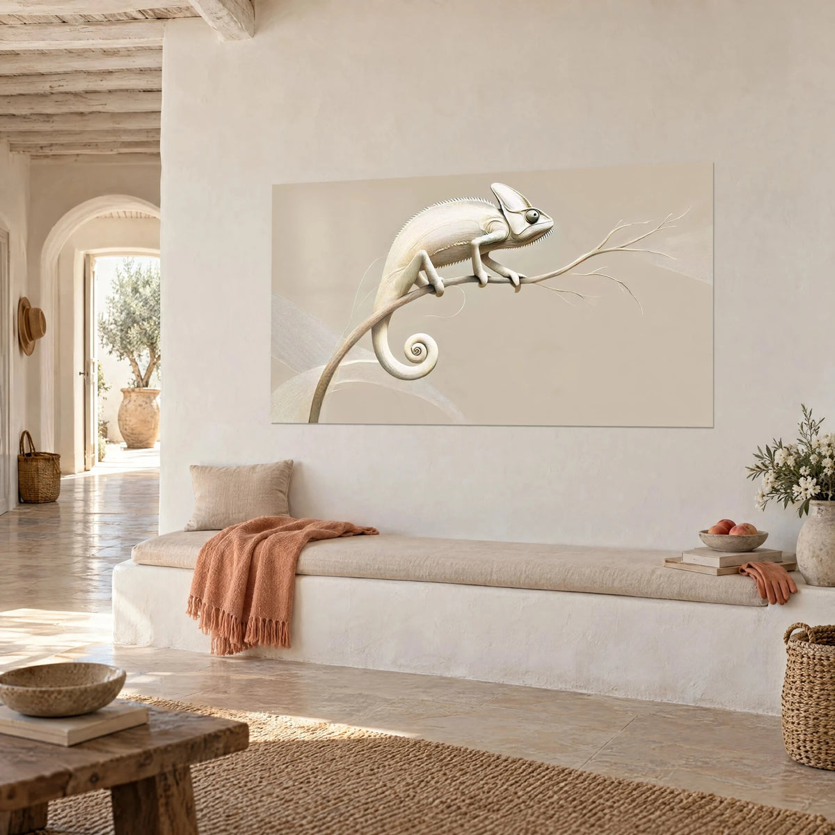 Tableau reptile crème aux fines stries dorées, queue enroulée sur fond sable, mur blanc d'une maison méditerranéenne