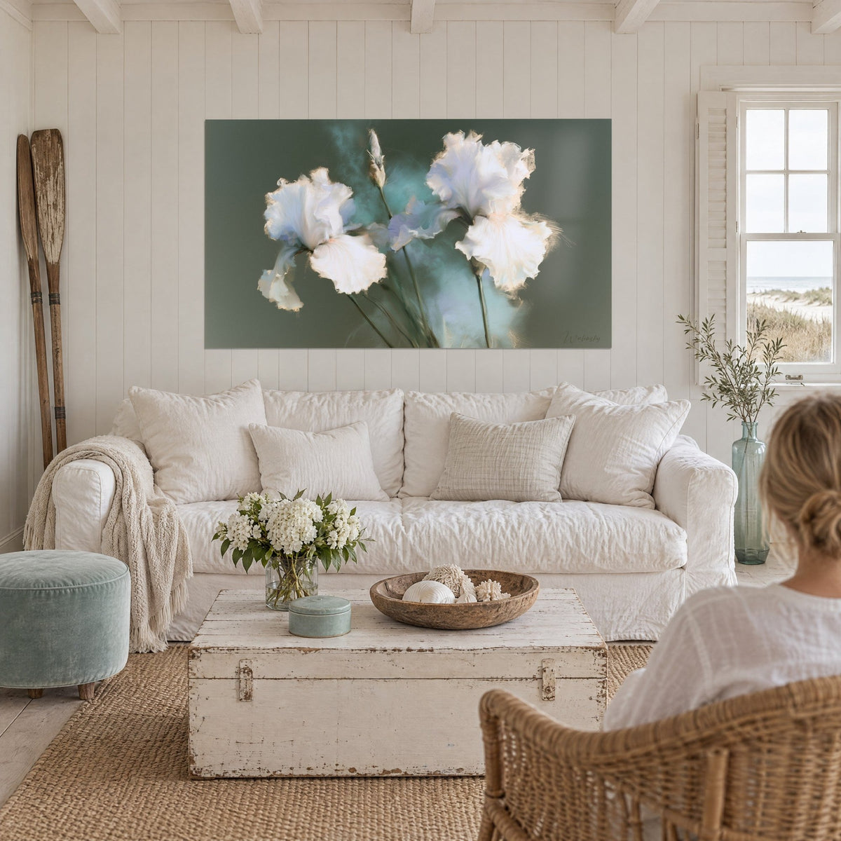 Gemälde weiße Iris mit zerknitterten Blütenblättern auf graugrünem Grund und türkisfarbenem Dunst, über einem Sofa in einem hellen Wohnzimmer
