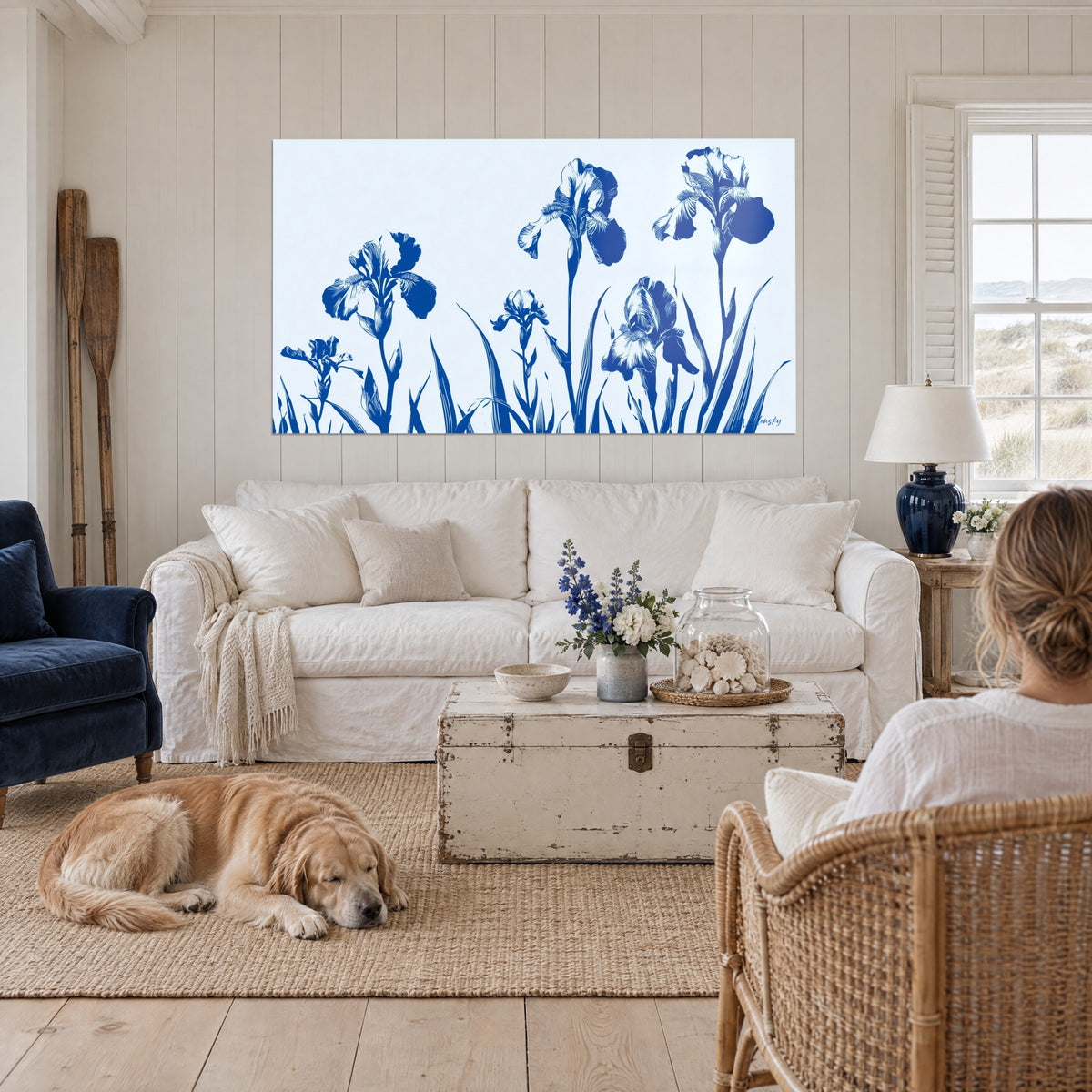Cuadro iris índigo en siluetas sobre fondo azul pálido, tallos esbeltos, encima de un sofá en un salón luminoso