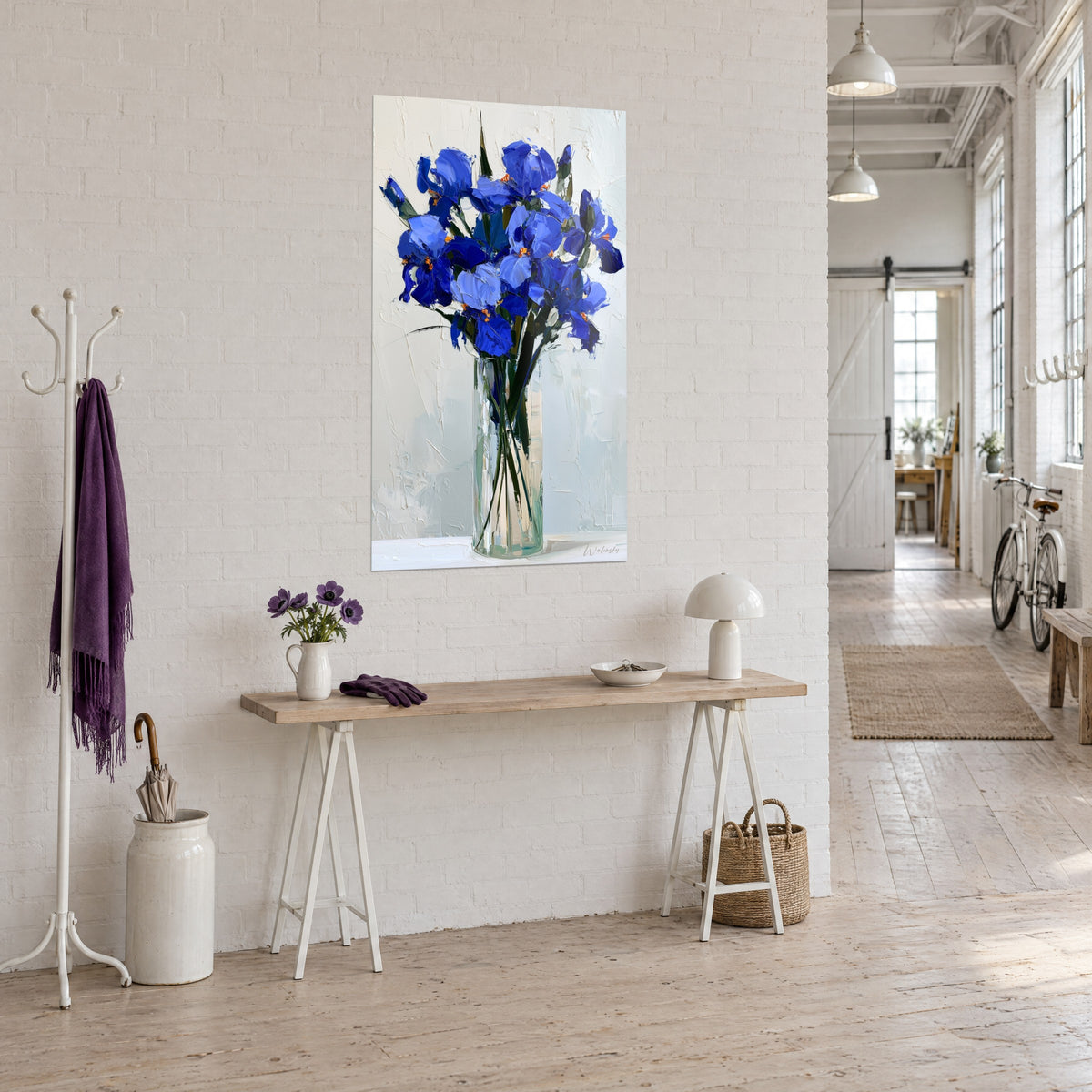 Wall art indigo and lavender blue iris bunch on a chalky white background, cylindrical vase, wooden console and the loft hallway in perspective