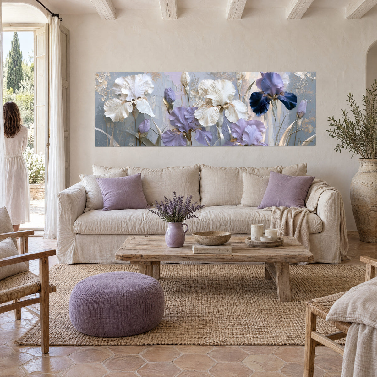 Wall art White irises with frilled petals and purple flowers on a grey-blue background, woman seen from behind, above a sofa in a bright living room
