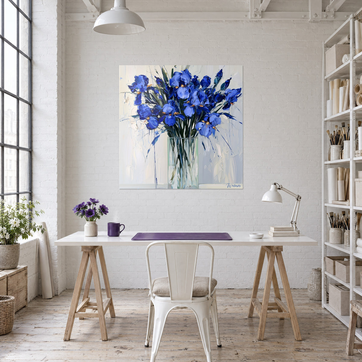 Cuadro flores de iris en plena floración, pétalos cobalto sobre pared blanca, colgado sobre un escritorio de madera y una lámpara, loft