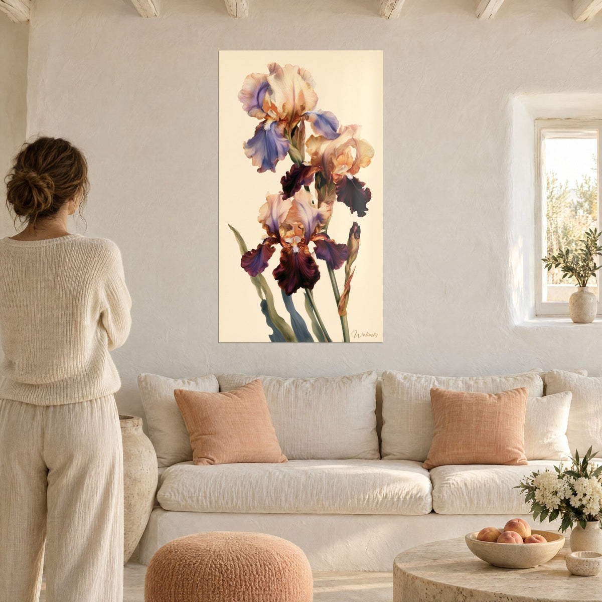 Gemälde mit drei bärtigen Iris in Lavendel und Purpur mit gewellten Blütenblättern, Frau von hinten, über einem Sofa in einem hellen Wohnzimmer