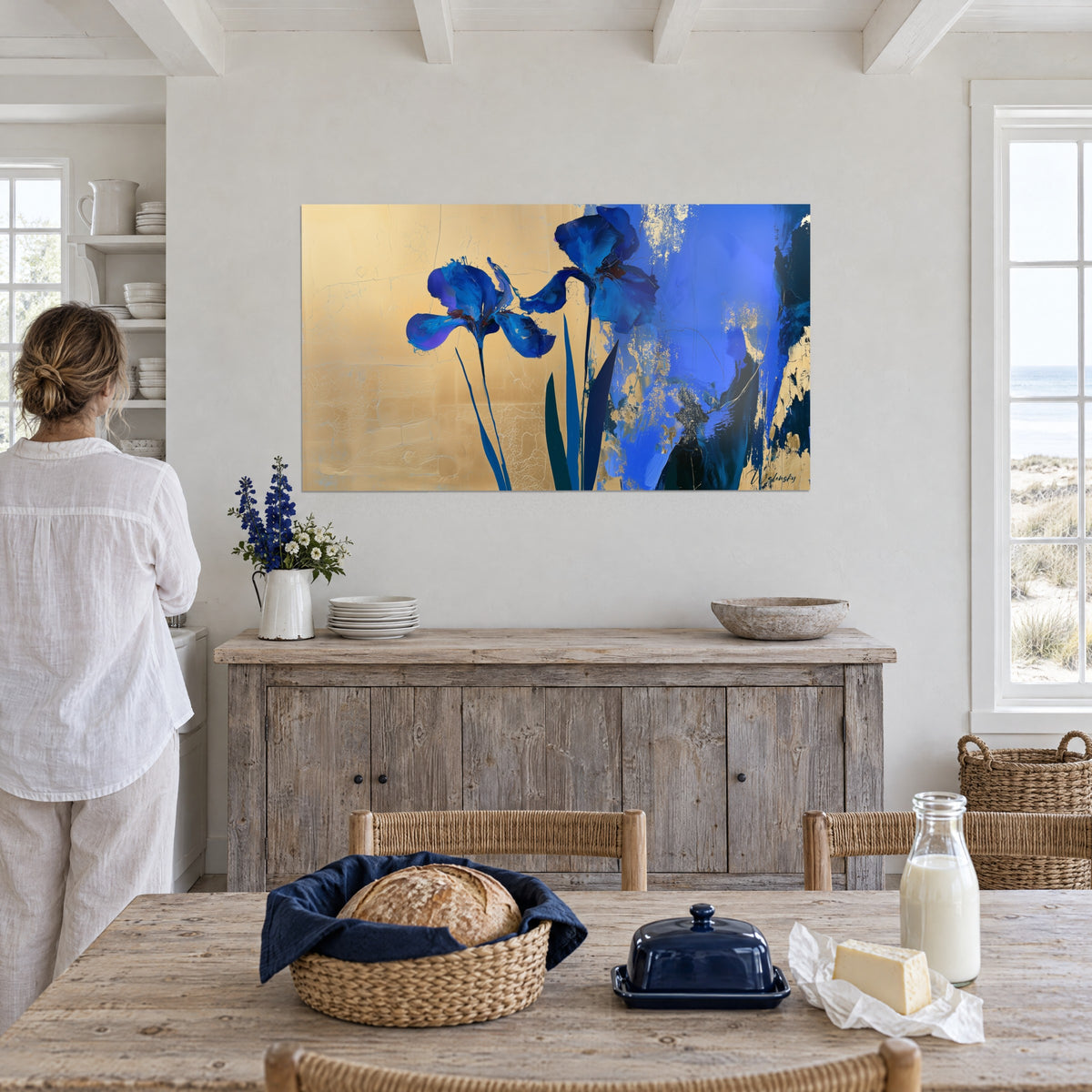 Tableau bouquet d'iris cobalt peints à larges coups de pinceau, fond ocre doré, femme de dos devant une commode patinée de bord de mer