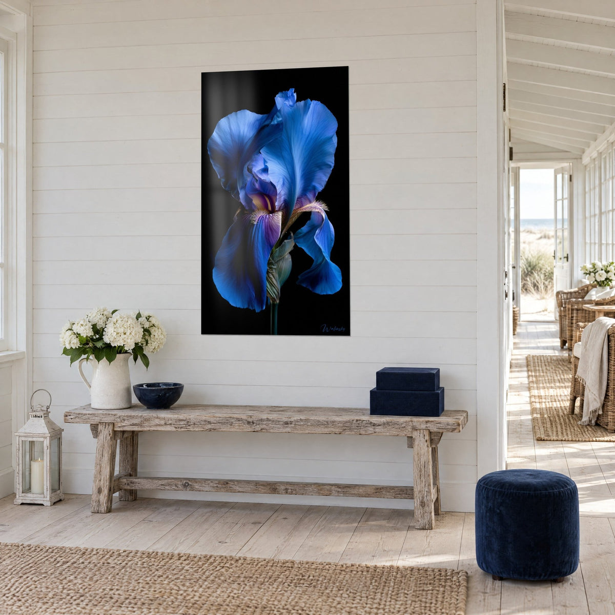Wall art of an indigo and violet iris bloom, satin-smooth petals on a black background, beside a raw wood console, seaside home