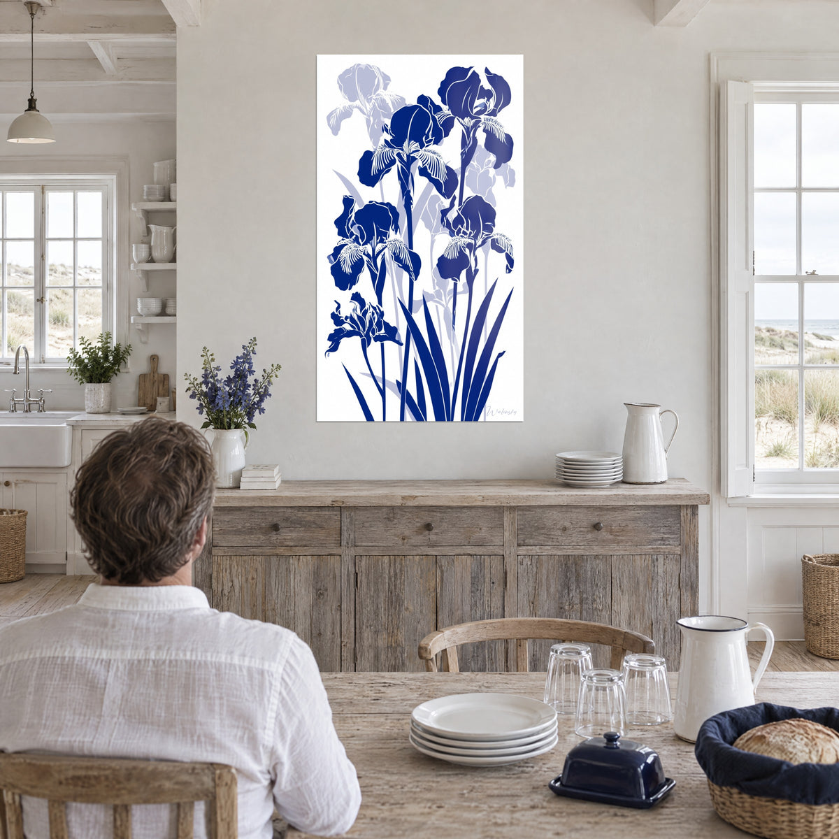 Cuadro ramo gráfico de iris cobalto y gris azulado pálido, colgado cerca de una ventana en una cocina junto al mar