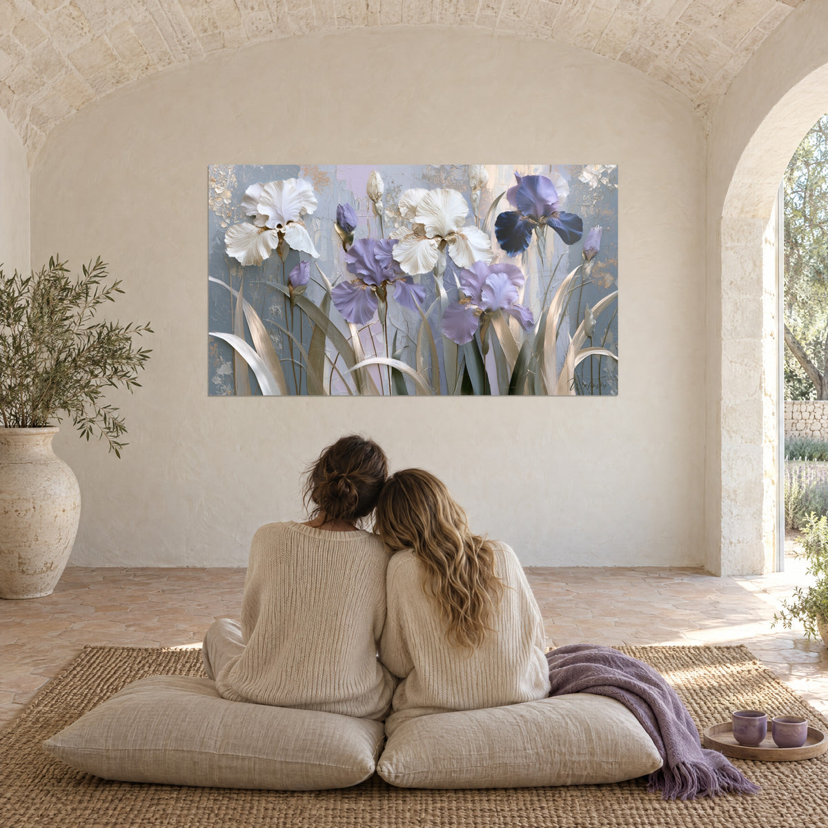 Cuadro de floración de iris lavanda y marfil, relieve de materia gruesa, contemplada por dos mujeres sentadas en cojines en el mas