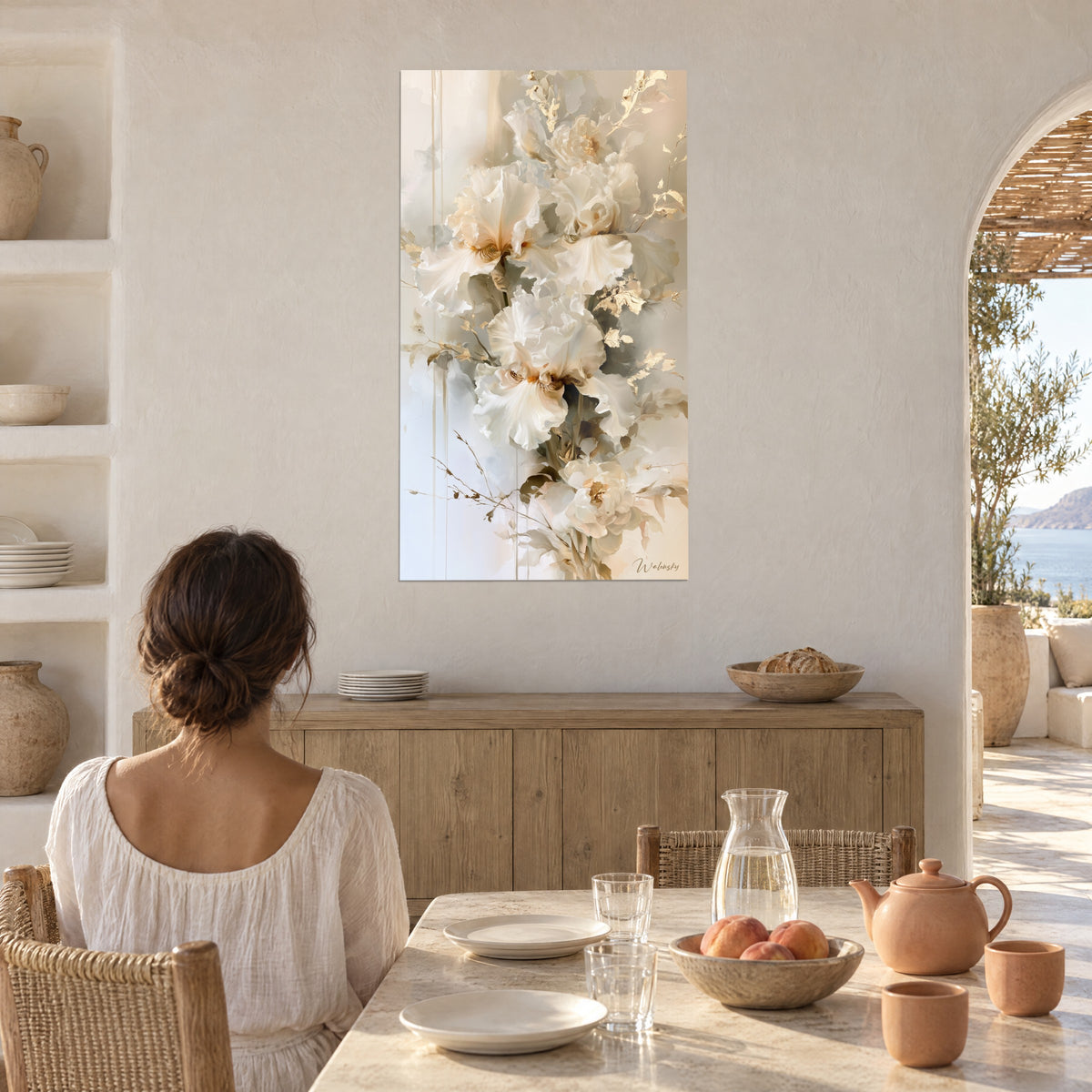 Cuadro iris marfil de corazones ámbar y ramitas doradas, mujer de espaldas sentada a la mesa, pared encalada, arco y mar al fondo