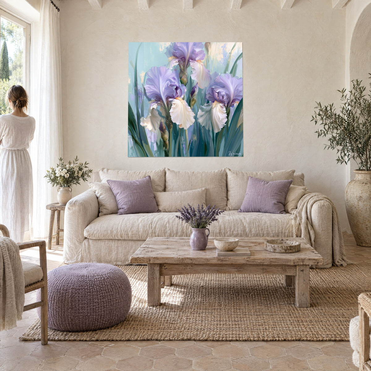 Cuadro de lirios lavanda de pétalos ondulados, crema y verde salvia, sobre un sofá en un salón luminoso