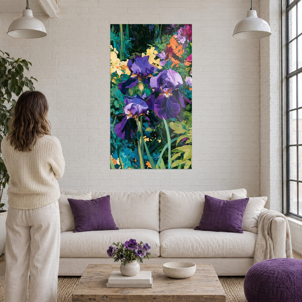 Cuadro de iris morados en pintura gruesa, follaje verde esmeralda y toques naranja, sobre un sofá en un salón luminoso