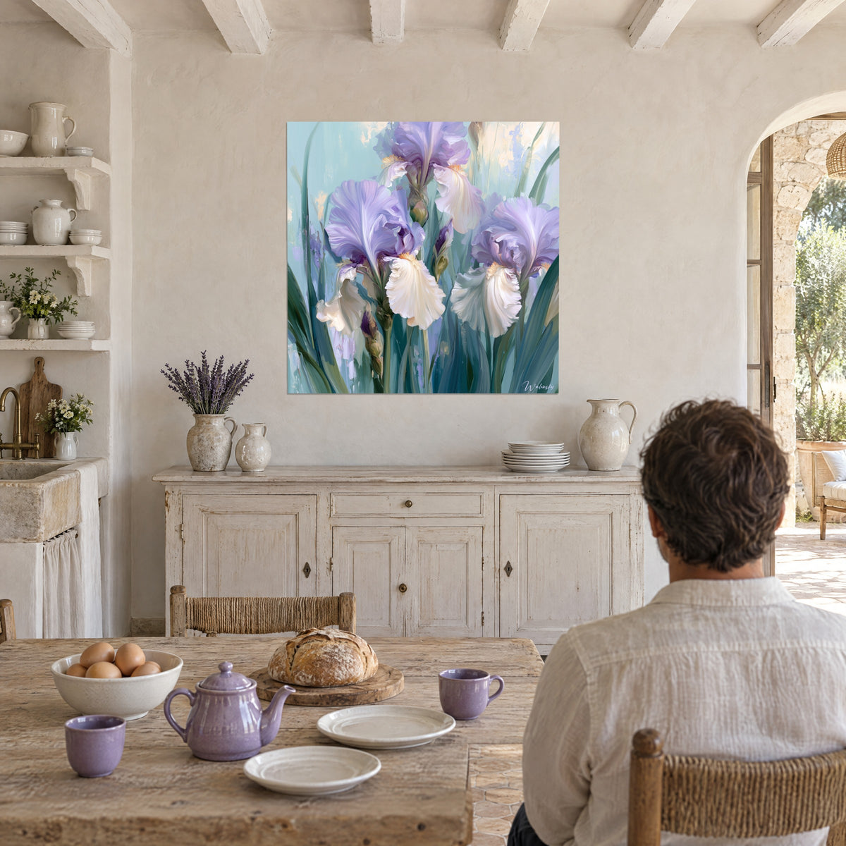 Cuadro de lirios con pintura gruesa, volantes blancos y malva, mesa de madera y cuencos lila en la cocina del mas