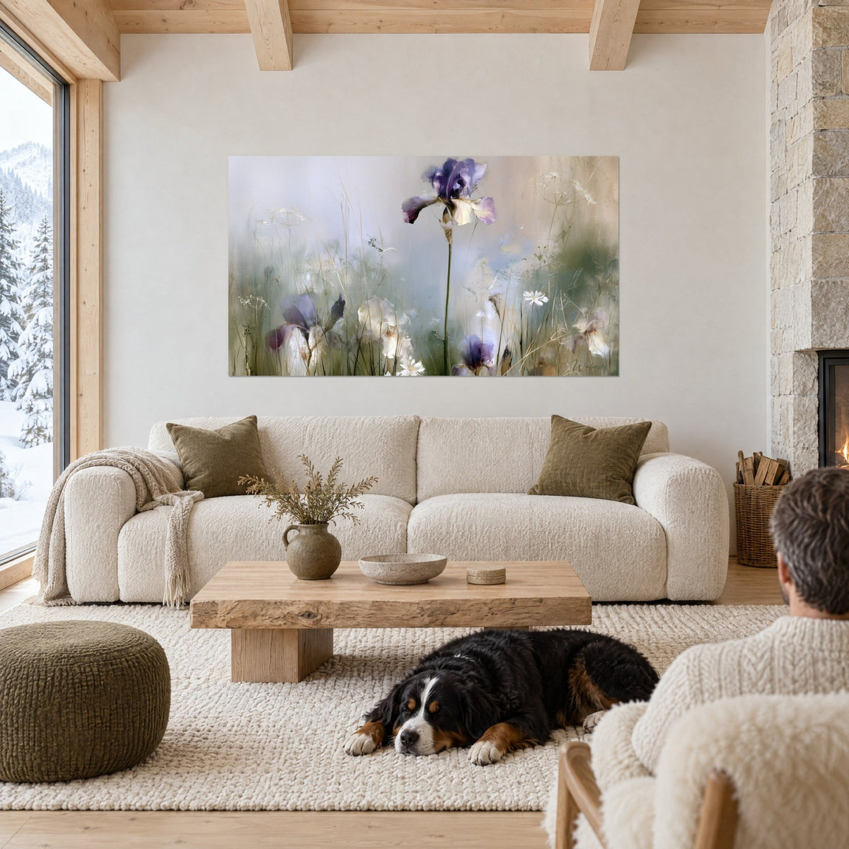 Wall art of a purple iris standing tall on its stem, misty grey-blue background, black dog lying down, above a sofa in a bright living room