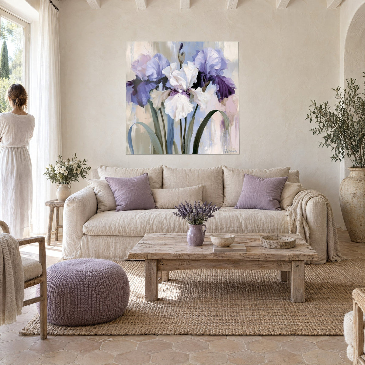Gemälde weiße Iris cremefarben zwischen zwei malvenfarbenen Blüten, dicke Spachtelstriche, Frau von hinten, über einem Sofa in einem hellen Wohnzimmer