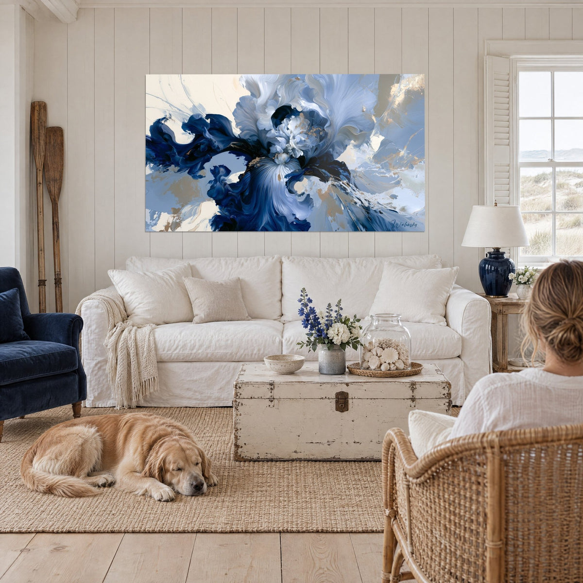 Quadro iris blu navy con petali setosi e tocchi dorati, retriever sdraiato accanto al divano, sopra un divano in un soggiorno luminoso
